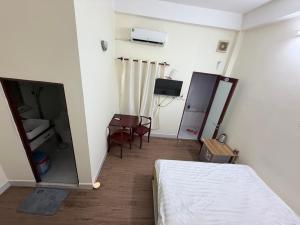 a bedroom with a bed and a table and a television at Ba Doan 2 in Con Dao
