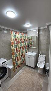 a bathroom with a toilet and a washing machine at Берег 2 in Bosteri +34 photos