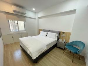 a bedroom with a bed and a blue chair at Happiness B&B in Linbian
