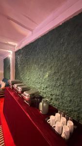 a table with a red table cloth and a green wall at Laalsa Retreat in Darjeeling