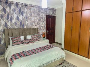 a bedroom with a large bed with pillows on it at Elite properties in Kampala