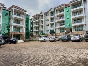 a parking lot in front of a large building at Elite properties in Kampala