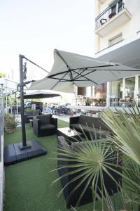 a patio with tables and umbrellas in a building at Hotel Seaview in Rimini