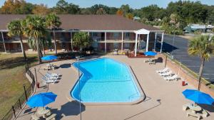 an overhead view of a swimming pool with blue umbrellas at Super 8 by Wyndham Lake City in Lake City