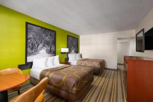 a hotel room with two beds and a table at Super 8 by Wyndham Lake City in Lake City
