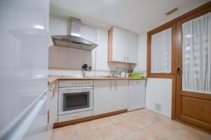a kitchen with white cabinets and a stove top oven at Costa Esuri in Ayamonte
