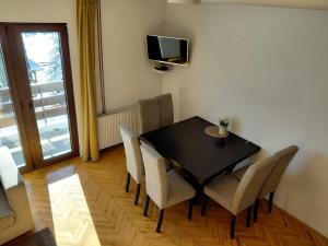 a dining room with a table and chairs and a television at Zlatibor Tornik View in Zlatibor