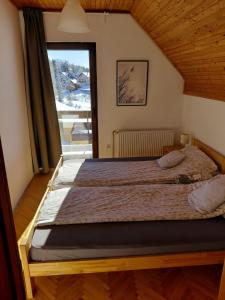 a bed in a room with a large window at Zlatibor Tornik View in Zlatibor