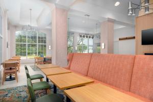 a restaurant with tables and chairs and a couch at Hampton Inn & Suites-Austin Airport in Austin