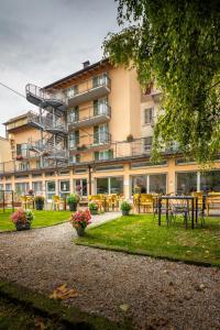 a building with tables and chairs in front of it at Ostello Città di Rovereto in Rovereto