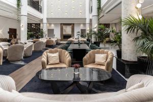 a lobby with couches and a table and chairs at Hilton Nicosia in Nicosia