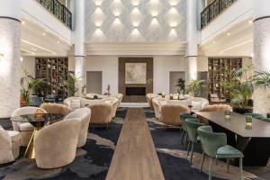 a hotel lobby with tables and chairs at Hilton Nicosia in Nicosia