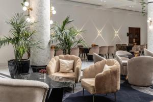 a lobby with chairs and a table and tables at Hilton Nicosia in Nicosia +89 photos