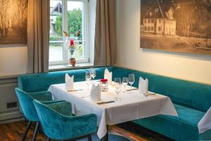 a dining room with a white table and blue chairs at Landhaus Hechtsberg in Hausach