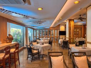 a dining room with tables and chairs at Golden Beach Hotel Pattaya in Pattaya