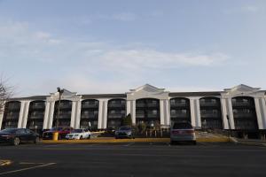 a large building with cars parked in a parking lot at TraveIodge by Wyndham Parsippany in Parsippany