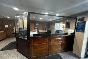 a reception desk with a large mirror in a room at TraveIodge by Wyndham Parsippany in Parsippany