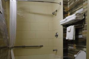 a bathroom with a shower and a toilet and towels at TraveIodge by Wyndham Parsippany in Parsippany +4 photos