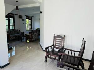 a room with rocking chairs and a white wall at Matara Villa in Matara