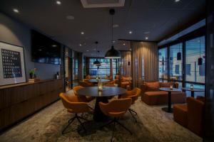 a restaurant with tables and chairs and a couch at Scandic Karlstad City in Karlstad