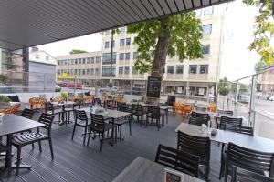 an outdoor patio with tables and chairs and a building at Scandic Karlstad City in Karlstad