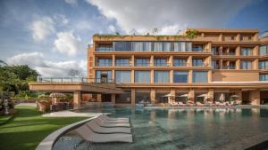 a hotel with a swimming pool in front of a building at Noema Resort Pererenan in Canggu