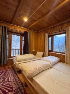 two beds in a room with two windows at The Quiet Corner in Gushaini