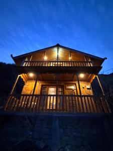 a log cabin with a porch at night at The Quiet Corner in Gushaini