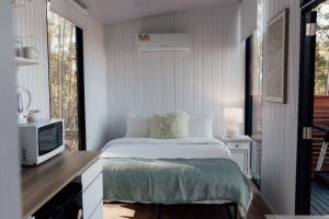 a bedroom with a bed and a television in it at Tiny Tamborine 2 by Tiny Away in Wongawallan