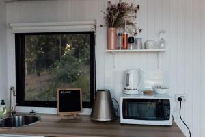 a kitchen counter with a microwave and a window at Tiny Tamborine 2 by Tiny Away in Wongawallan +26 photos