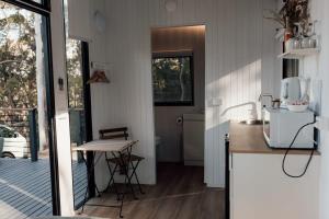 a kitchen with a counter and a table in a room at Tiny Tamborine 2 by Tiny Away in Wongawallan