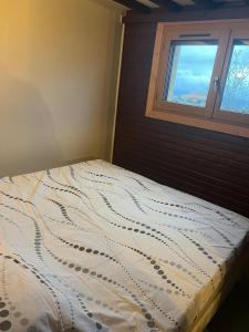 a bed in a bedroom with a window at Le Chalet in Les Costes-Gozon +3 photos