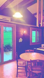 a dining room with a table and chairs and a window at Le Chalet in Les Costes-Gozon