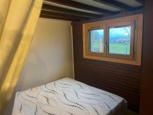 a small bedroom with a bed and a window at Le Chalet in Les Costes-Gozon