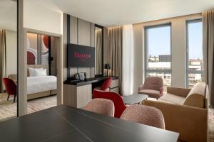 a hotel room with a table and chairs and a bed at Ramada by Wyndham Zalau in Zalău