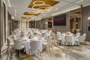 a conference room with white tables and white chairs at Ramada by Wyndham Zalau in Zalău +52 photos