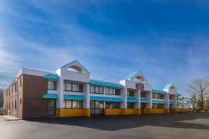 a large building with blue awnings in a parking lot at Howard Johnson by Wyndham Malden Boston Area in Malden