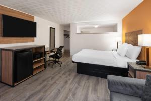 a hotel room with a bed and a desk at Howard Johnson by Wyndham Malden Boston Area in Malden