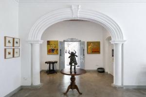 a room with an archway with a statue on a table at Indigaslanda Walawwa in Bopitiya