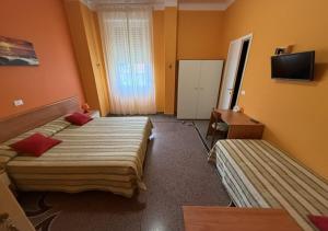 a hotel room with two beds and a television at Hotel Ines in Varazze