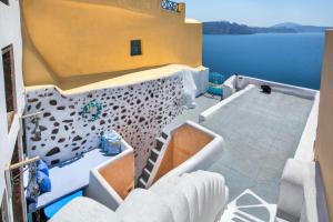 a balcony of a house with a view of the water at EverBlue Cave house by Thireon in Oia