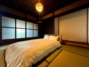 a bedroom with a large bed and two windows at #12 Sekigahara Hotaru in Sekigahara