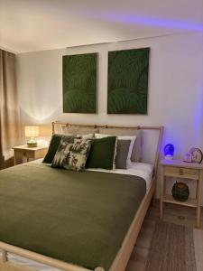 a bedroom with a bed with green sheets and two tables at UMANI Retreat 2 in Buşteni