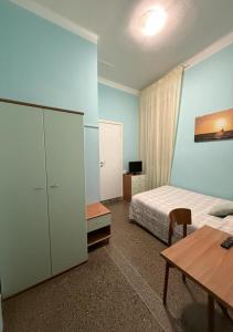 a bedroom with a bed and a desk and a table at Hotel Ines in Varazze