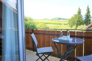 a table and chairs on a balcony with a view of a field at Hotel Garni Alte Post in Schallbach