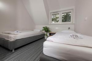 a bedroom with two beds and a window at Ośrodek Wypoczynkowy Caritas in Wałcz