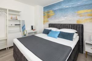 a bedroom with a large bed with blue pillows at Villa Panorama Dubrovnik in Mlini