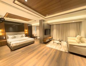 a hotel room with a bed and a couch at Hotel Bluebell in Kozhikode +97 photos