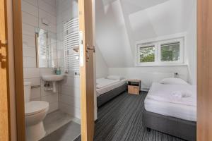 a bathroom with two beds and a toilet and a sink at Ośrodek Wypoczynkowy Caritas in Wałcz +66 photos