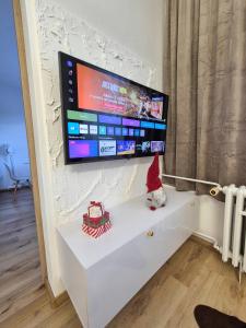 a santa claus doll sitting on a white dresser with a tv on at Apartmán Sárka Brezno in Brezno